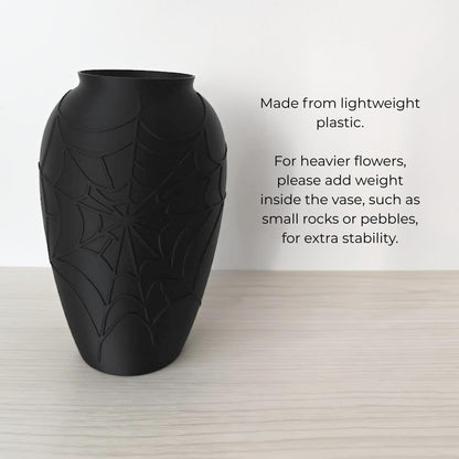 Lightweight black spider web vase with note to add rocks or pebbles for heavier flowers.