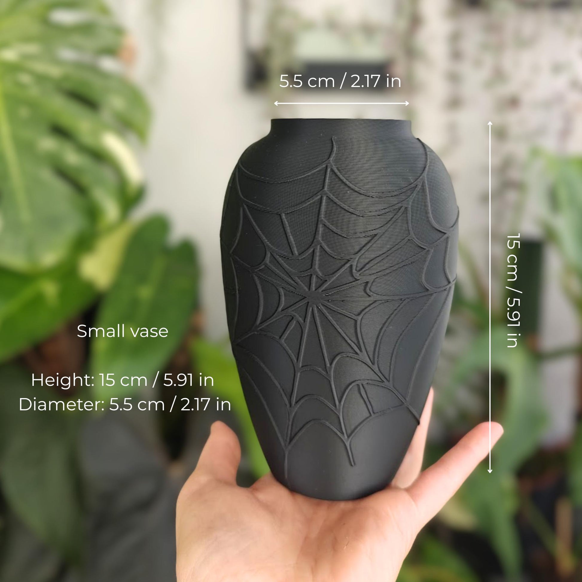 Small black spider web vase shown in hand with height and diameter measurements.
