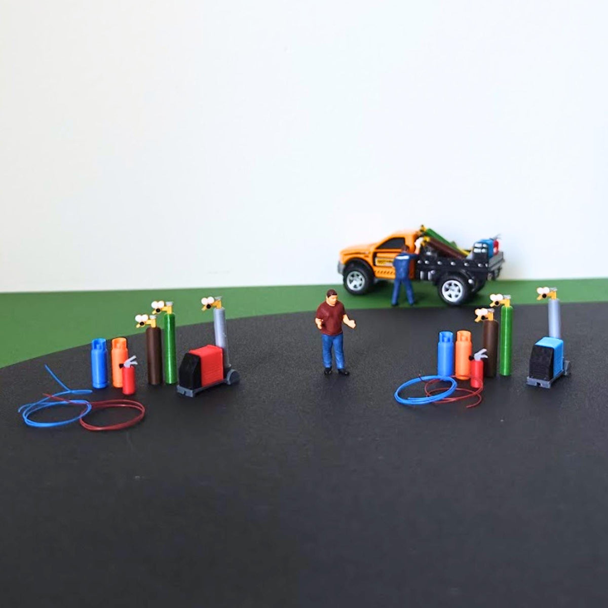 Red and blue workshop utility sets displayed together with a scale figure and model pickup truck.