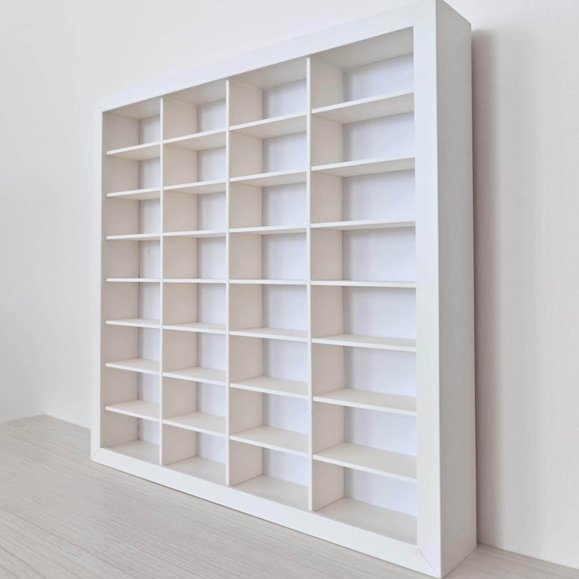 Close side view of the white display frame showing the interlocking horizontal shelves and vertical dividers.