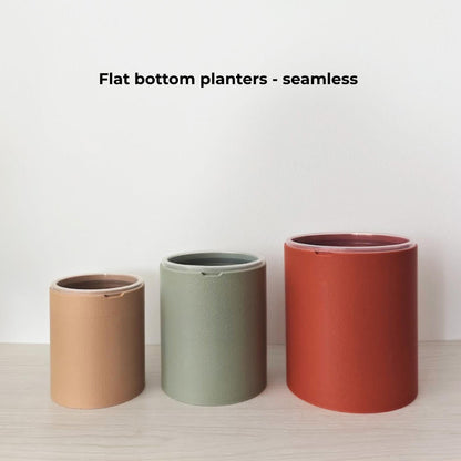 Three seamless flat-bottom outer planters with solid sides in latte brown, sage green and terracotta.