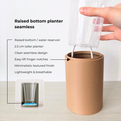 Terracotta raised-base planter with seamless solid sides, clear nursery pot and infographic explaining the self-watering reservoir.