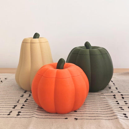Three pumpkin containers with removable lids in orange, dark green and desert tan, shown together as autumn and Halloween decor.
