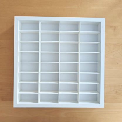 Front view of the completed empty white SANNAHED frame with 32 evenly arranged display compartments.