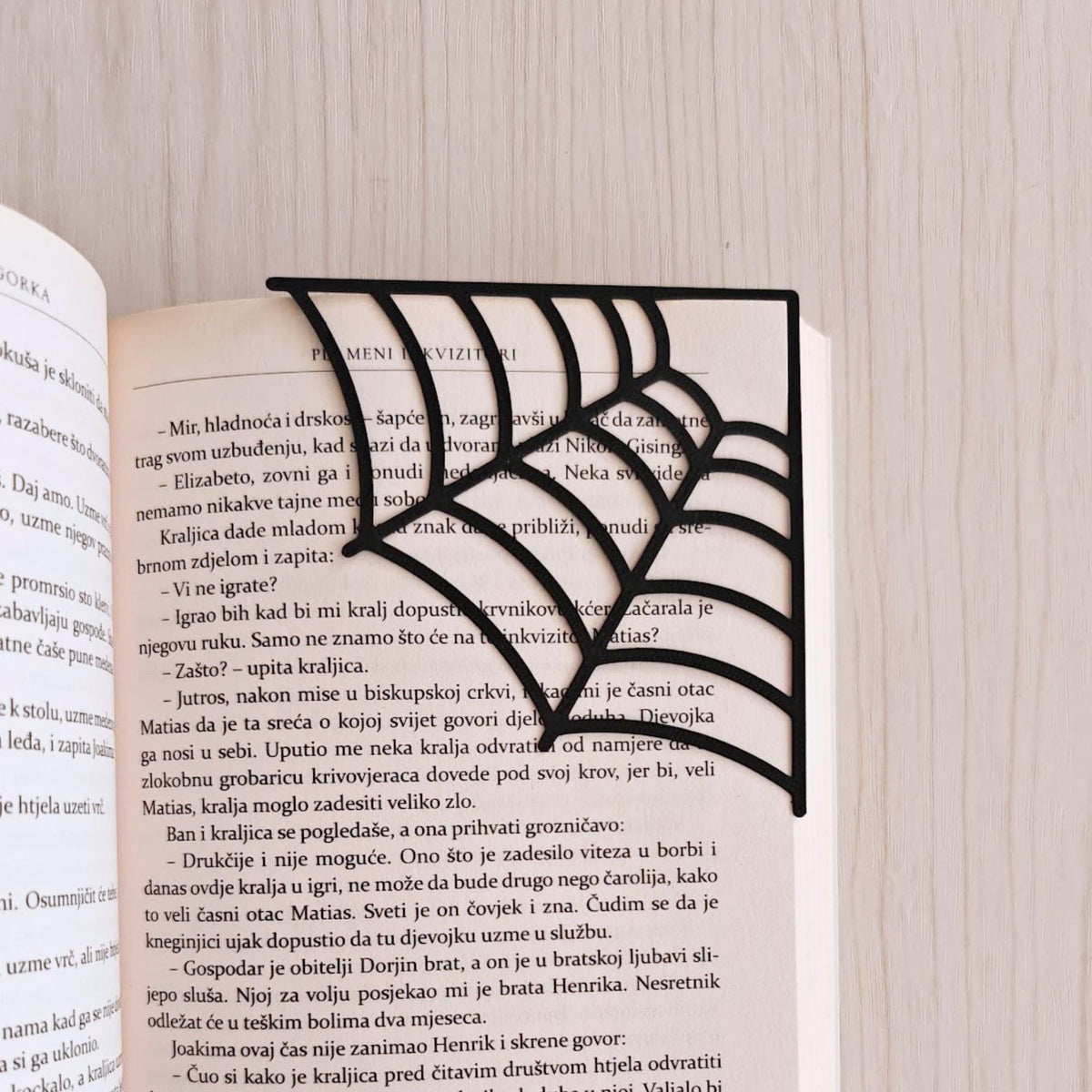 Close-up of black spiderweb bookmarks fitted over the corners of book pages