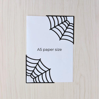 Spiderweb corner bookmarks shown on A5 paper for size comparison