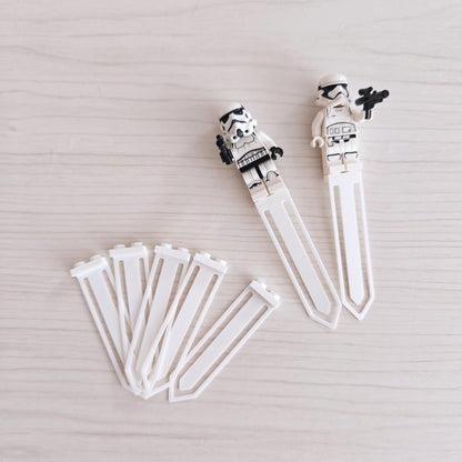 Set of five white bookmark clips with two clips holding brick-style minifigures