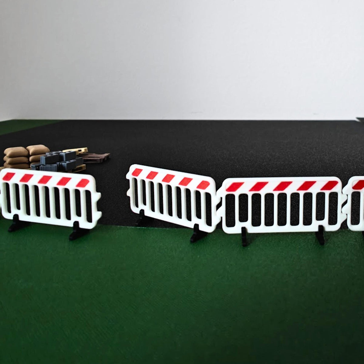 1:64 scale plastic barricades arranged around construction pallets and miniature vehicles