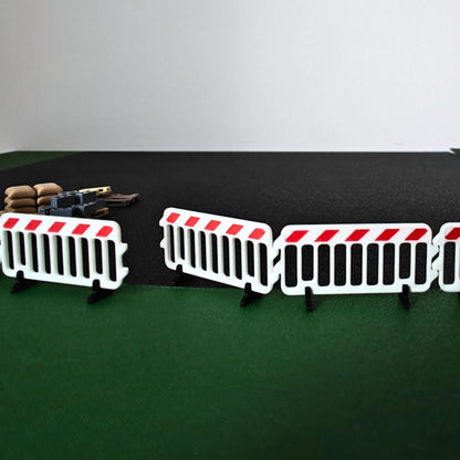 1:64 scale plastic barricades arranged around construction pallets and miniature vehicles