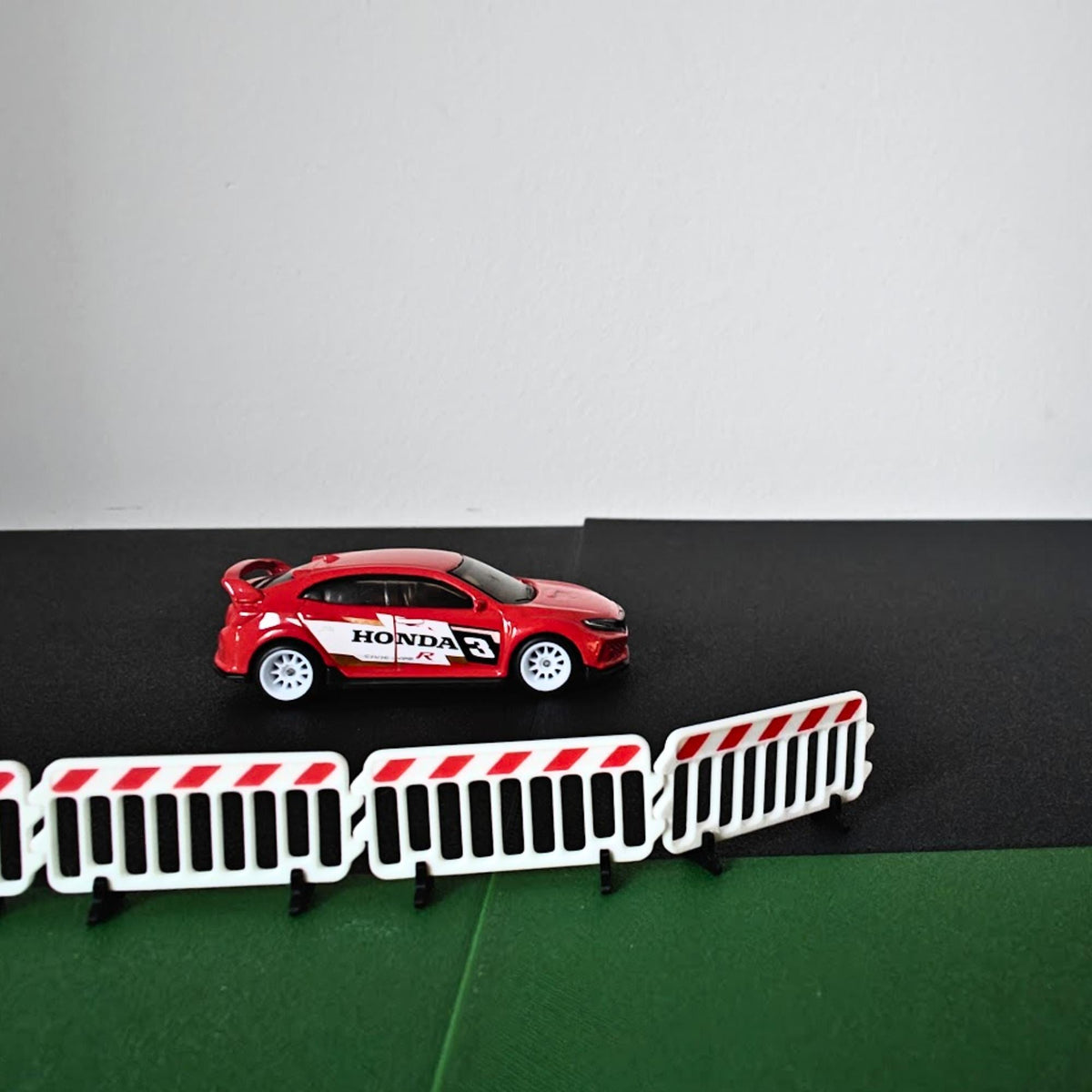 1:64 scale crowd control barricades displayed with a red model car diorama