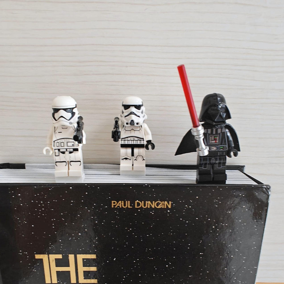 Minifigure bookmark clips attached to the top of a book with three brick-style figures
