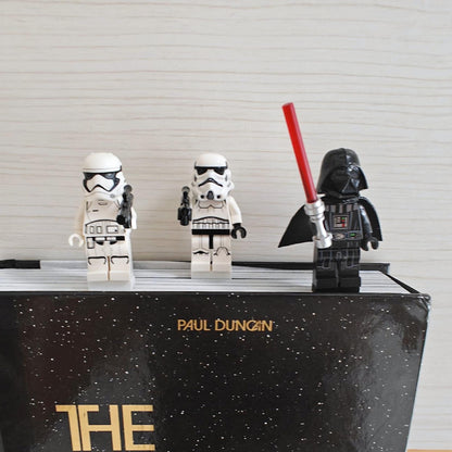 Minifigure bookmark clips attached to the top of a book with three brick-style figures