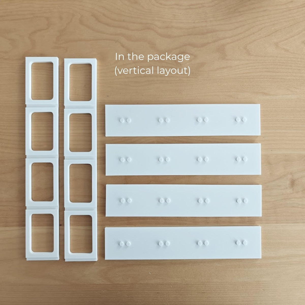 Parts included with the vertical VÄSTANHED insert: side grid supports and four white display shelves.
