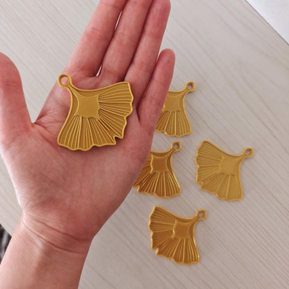 Gold ginkgo leaf ornament held in one hand to show the scale and size of the hanging decoration.