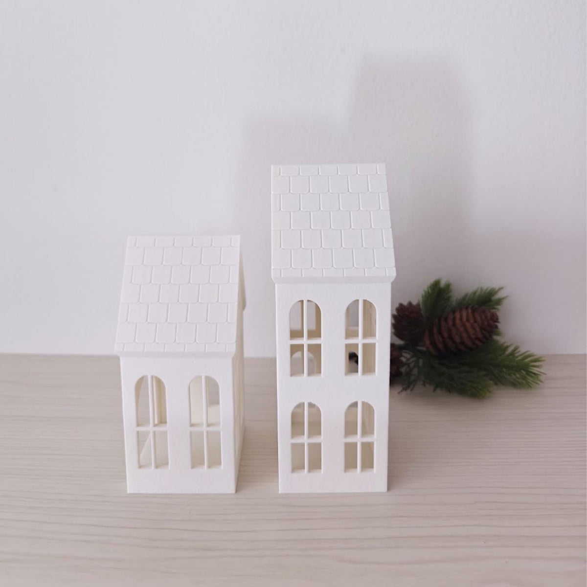 Front view of two white Christmas village house tealight shades