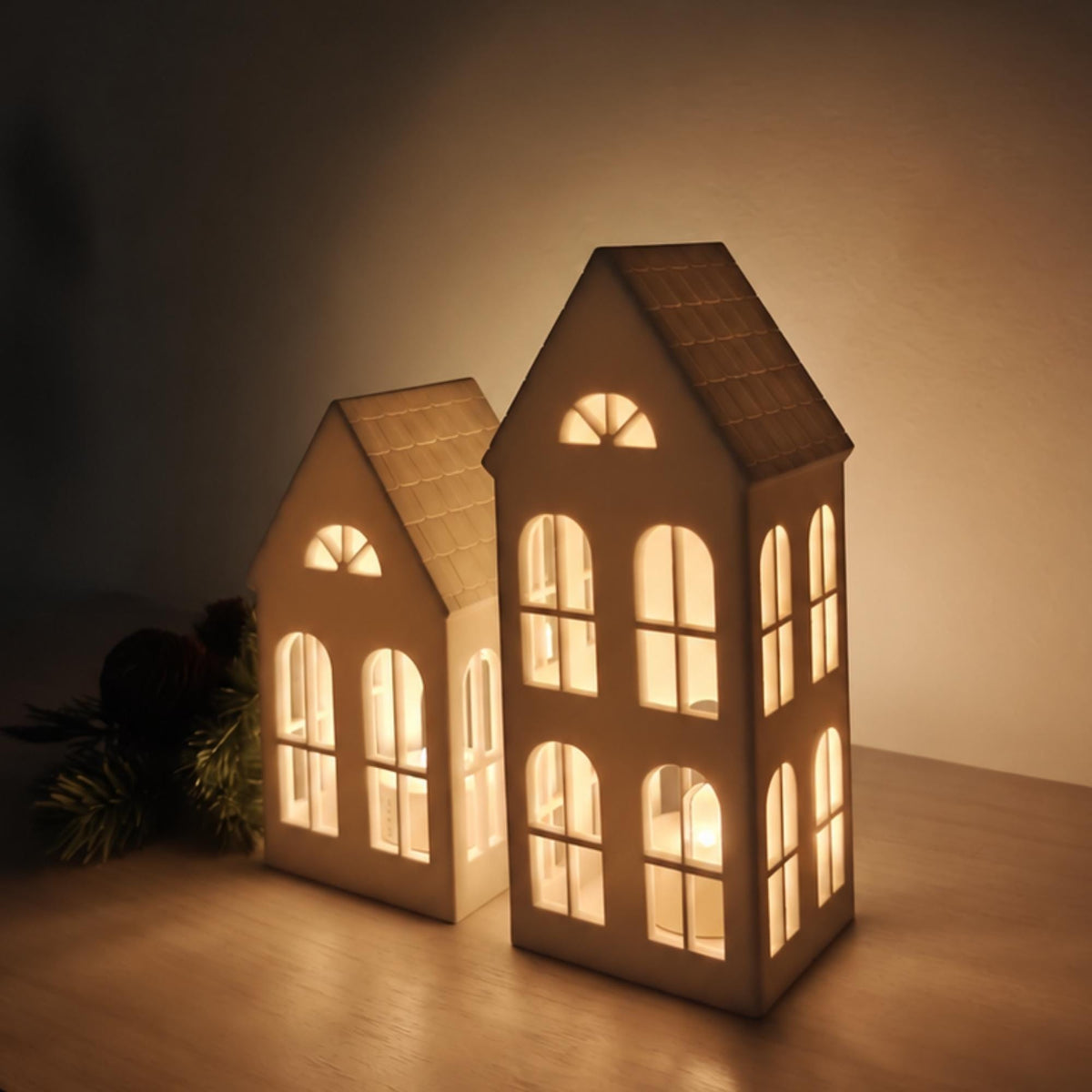Illuminated Christmas village house tealight holders glowing with warm LED light