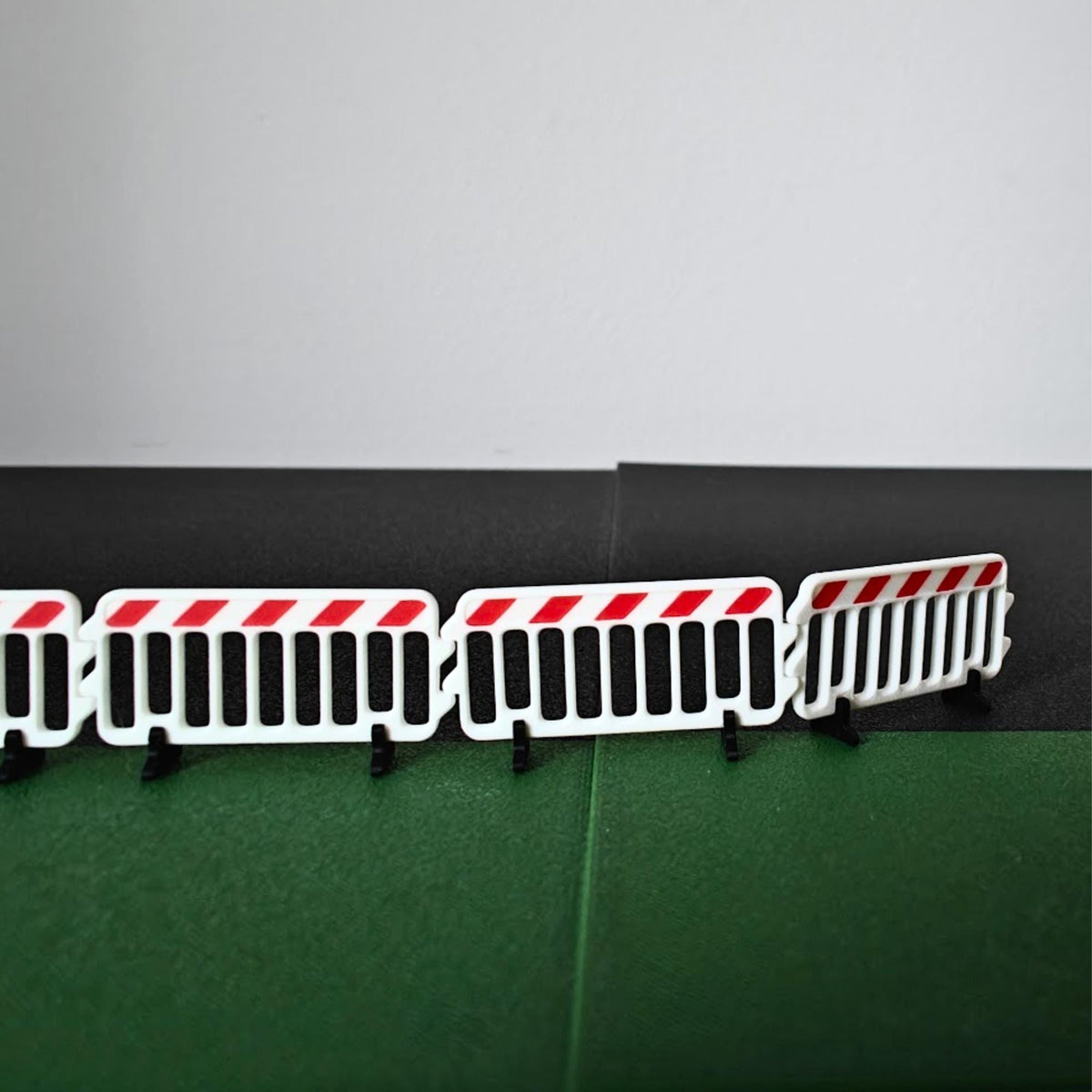 Miniature crowd control barriers in a curved roadwork scene