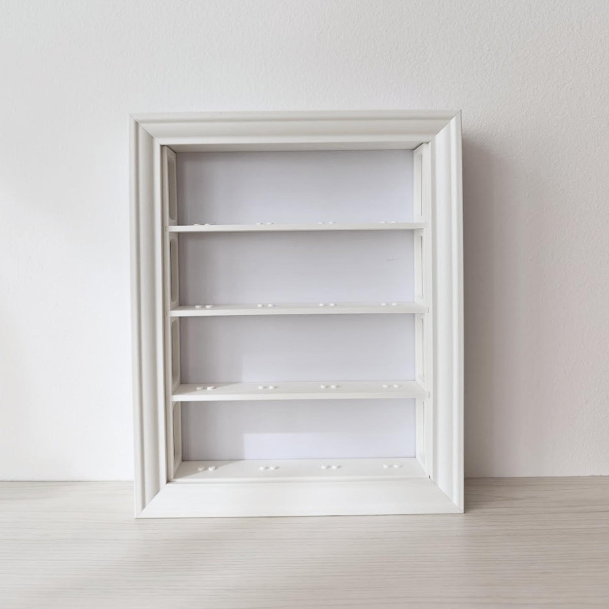 Empty white vertical VÄSTANHED frame insert with four horizontal display shelves.