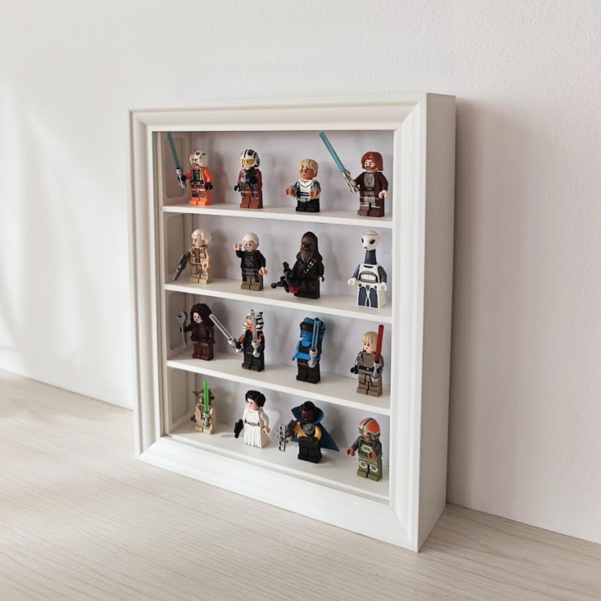Angled view of vertical IKEA VÄSTANHED display frame with white shelf inserts and LEGO minifigures.