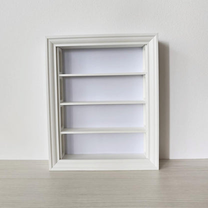 Front view of empty vertical VÄSTANHED frame insert with four smooth display shelves.