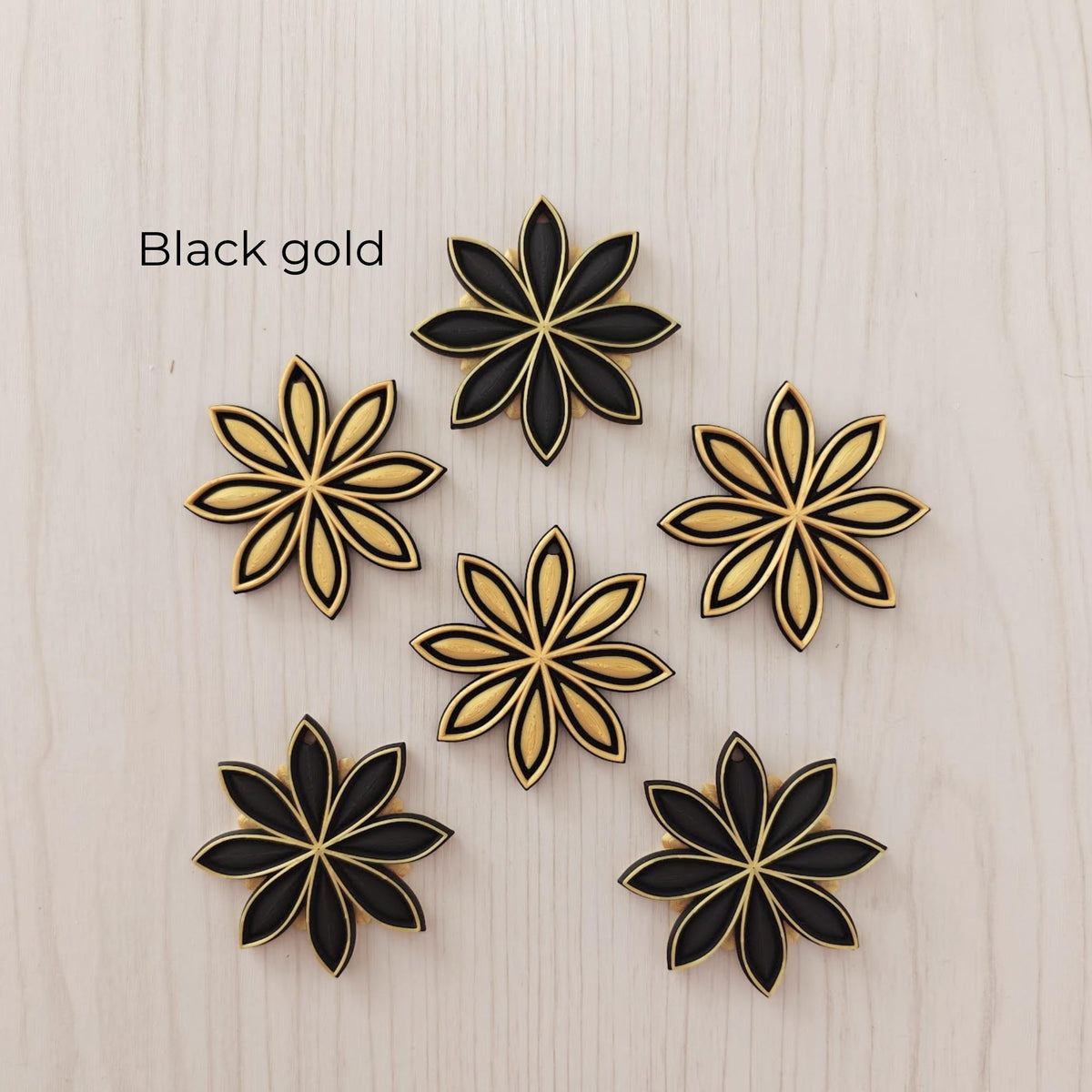 Black and gold star anise ornaments in alternating black and metallic gold designs.