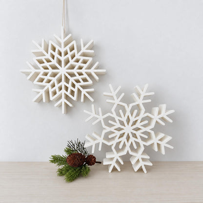 Two large white 3D printed snowflake decorations displayed as standing and hanging Christmas decor